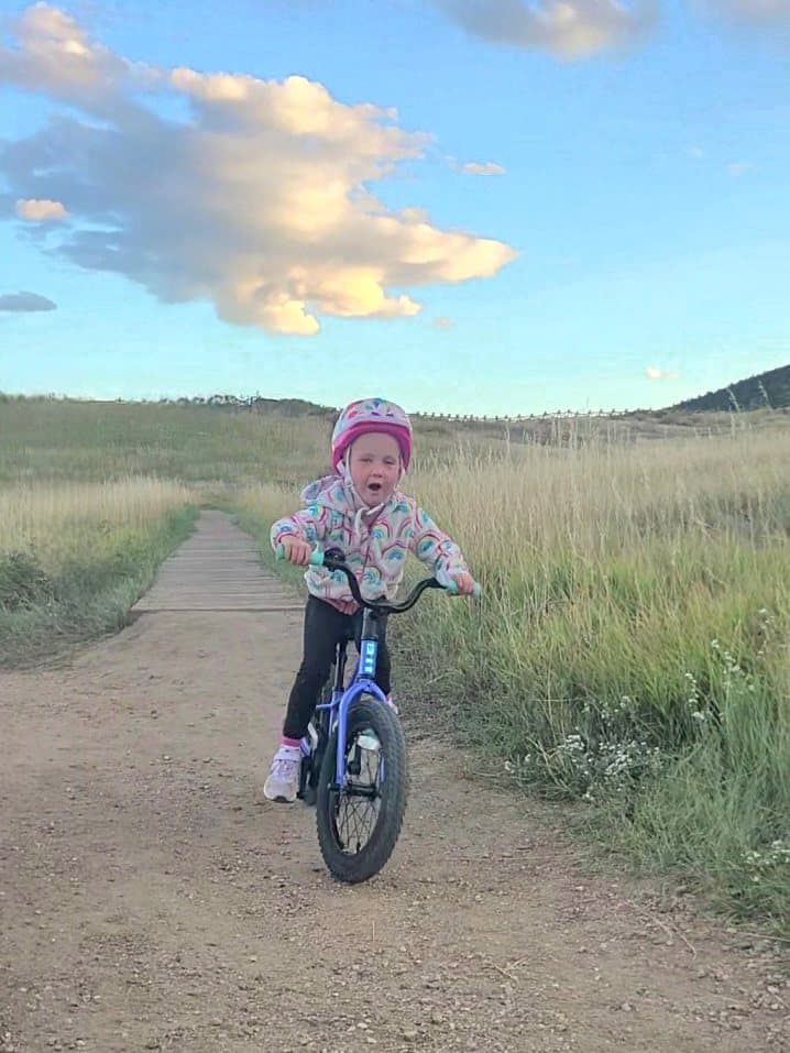 Bellamy riding her bike along a trail at sunset.