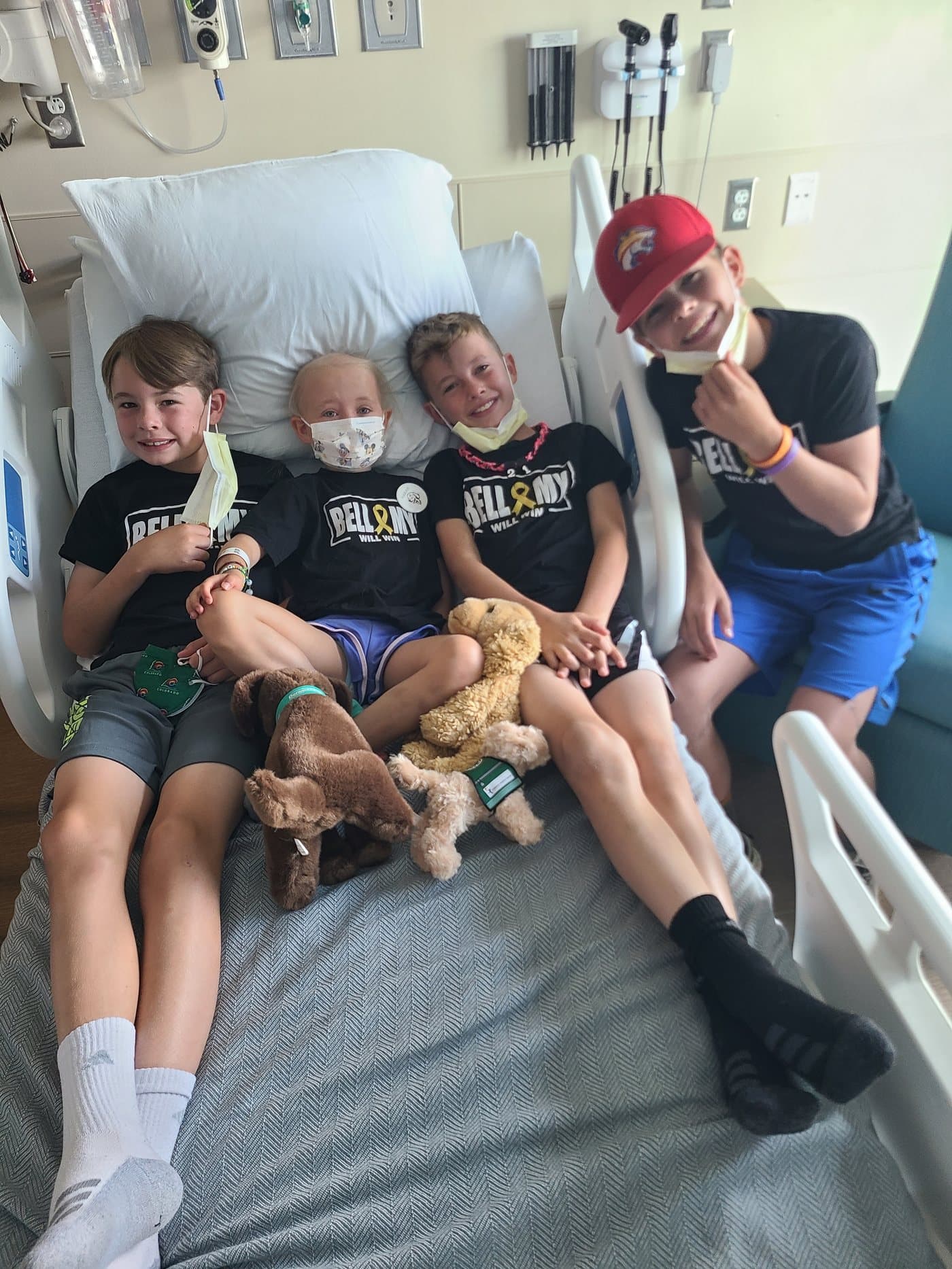 All four children piled onto the hospital bed together with their teddies.