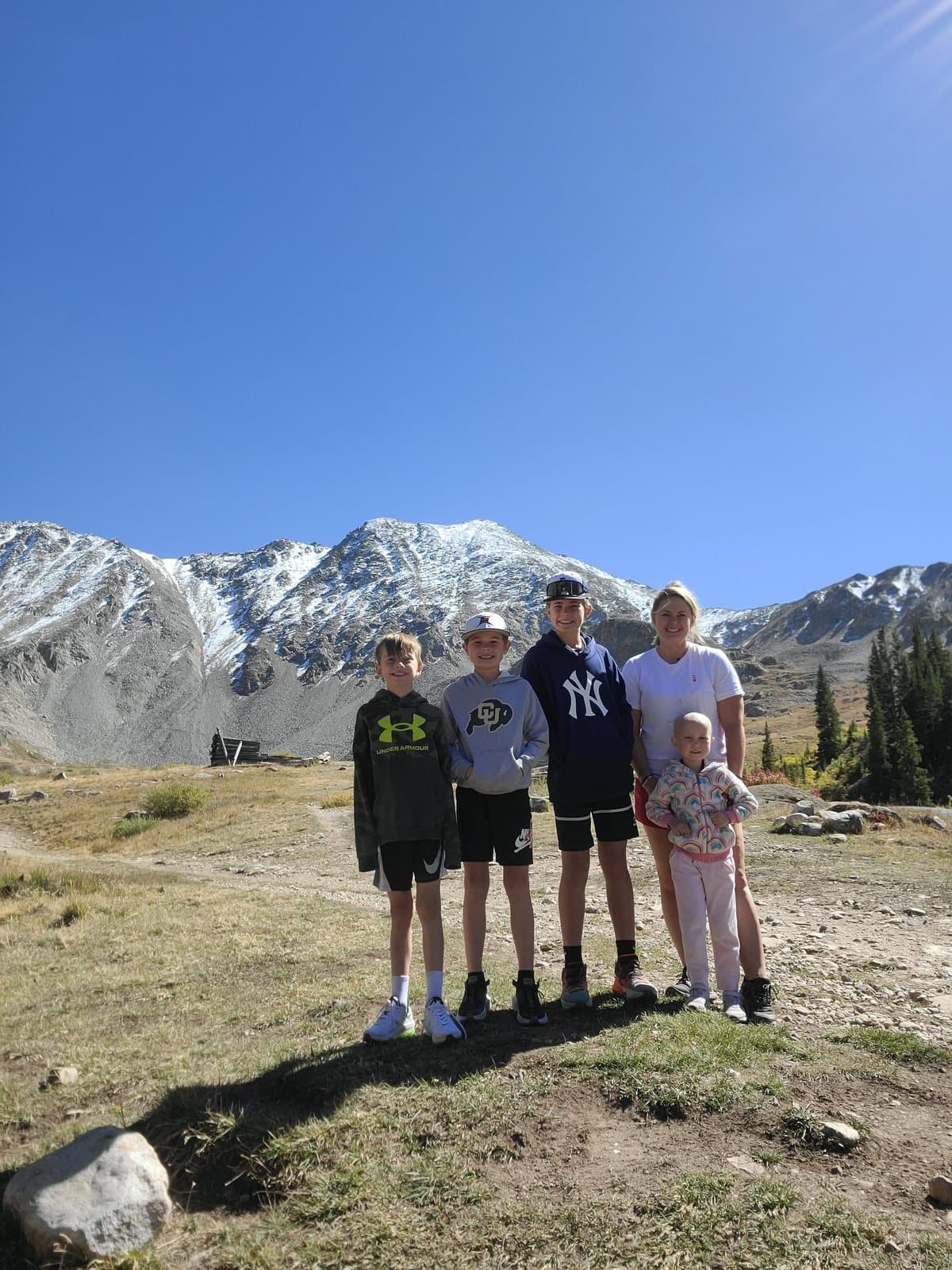 Sarah's four children lined up together with snow-capped mountains behind them.