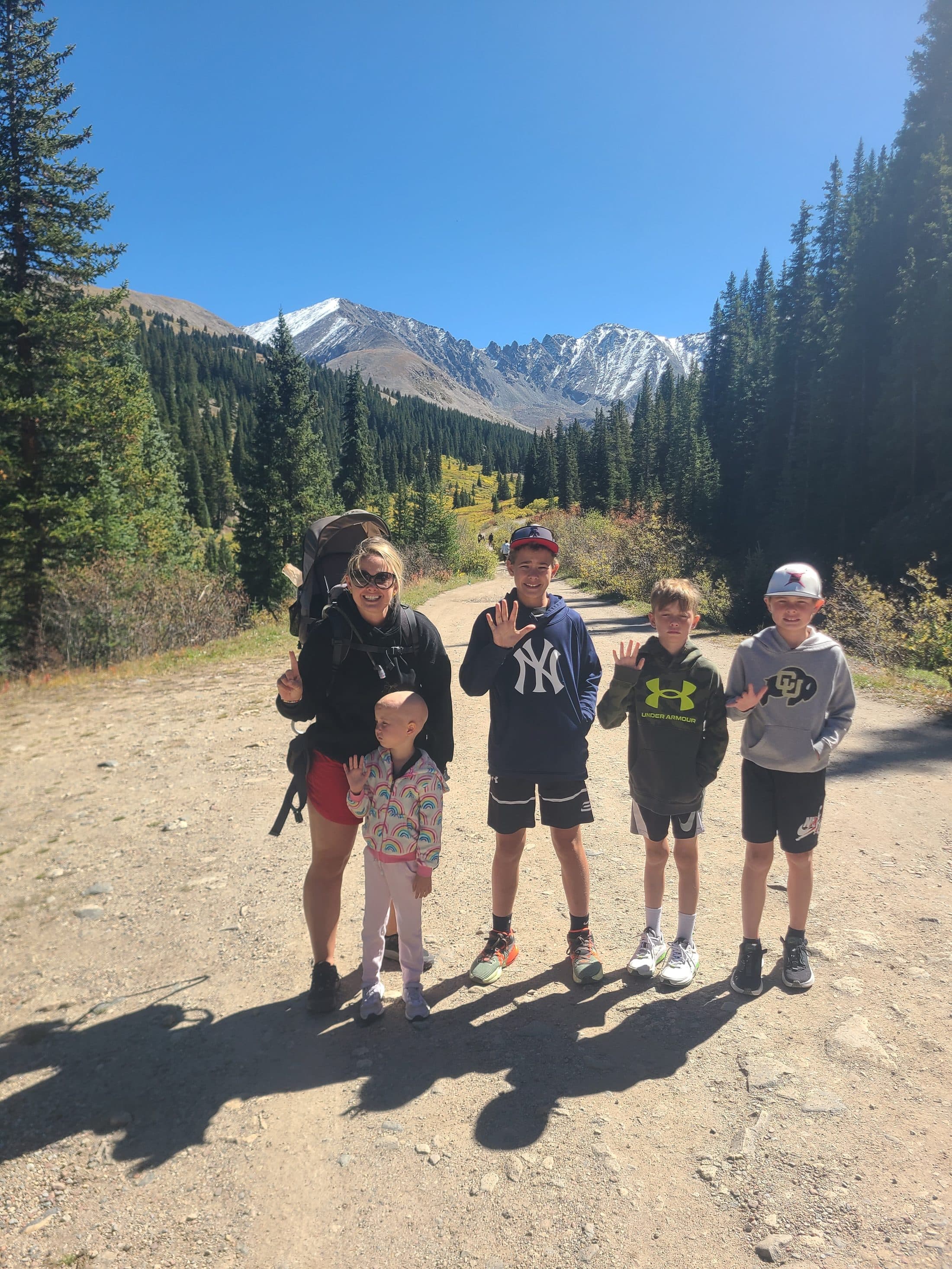 The whole family standing together on a mountain trail.